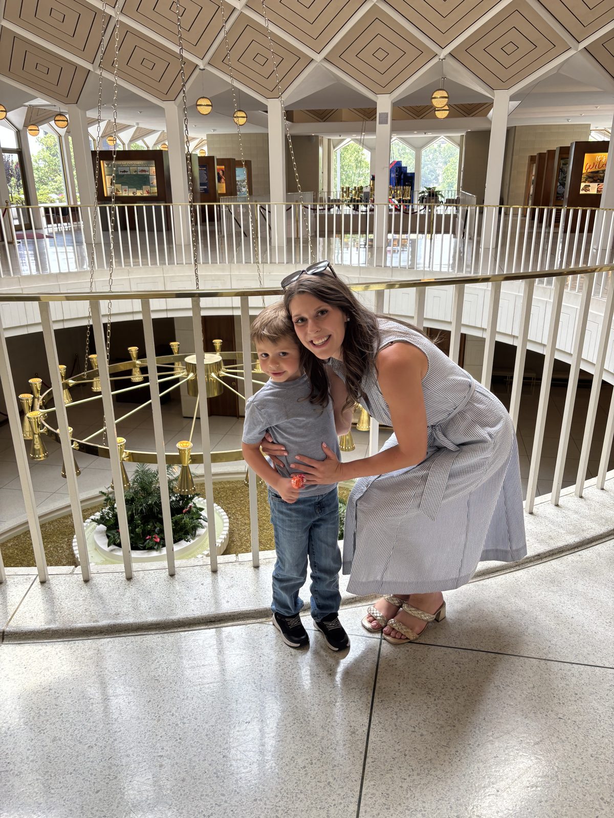 Caitlin with a young child in a sunlit atrium